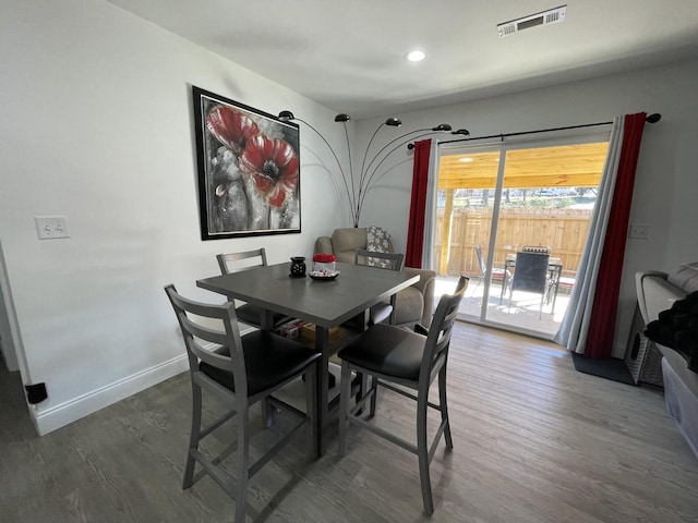 dining area featuring dark wood-type flooring, visible vents, and baseboards