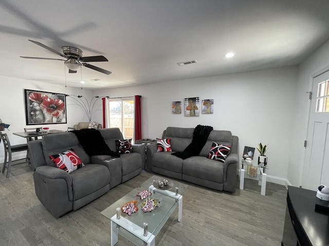 living room with baseboards, ceiling fan, visible vents, and wood finished floors