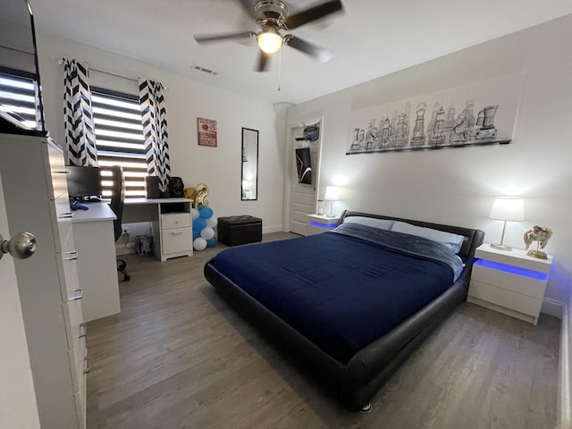 bedroom featuring ceiling fan, wood finished floors, and visible vents