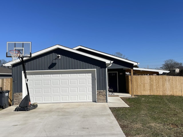 view of front of home with concrete driveway, stone siding, an attached garage, board and batten siding, and a front yard