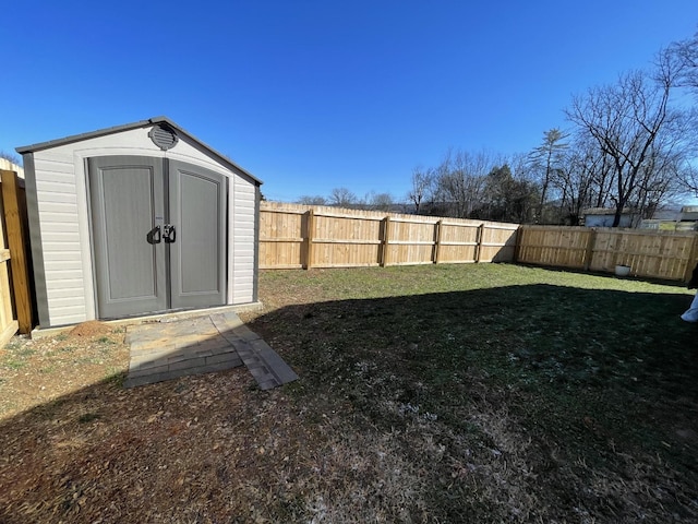 view of yard with an outbuilding, a storage unit, and a fenced backyard