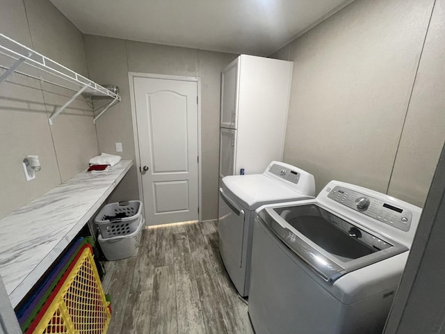 laundry area with washer and clothes dryer, dark wood finished floors, and cabinet space