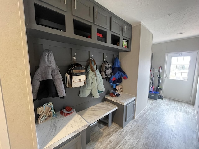 mudroom featuring light wood-type flooring and a textured ceiling