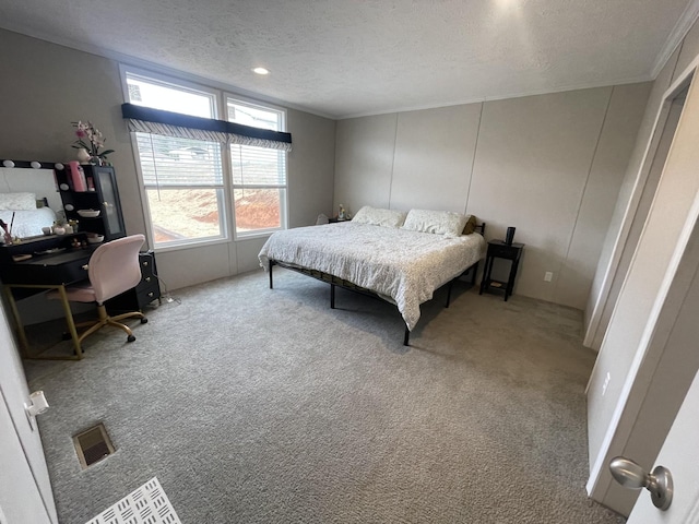 carpeted bedroom featuring a textured ceiling, visible vents, and crown molding