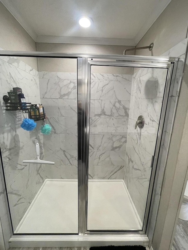 bathroom with a shower stall and ornamental molding