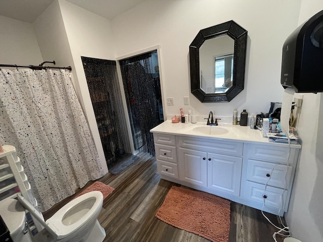 bathroom featuring a shower with shower curtain, wood finished floors, and vanity