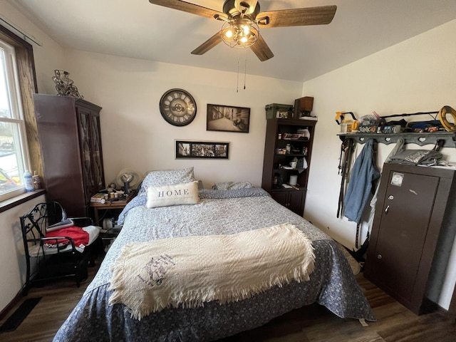 bedroom featuring dark wood-style flooring, multiple windows, and ceiling fan