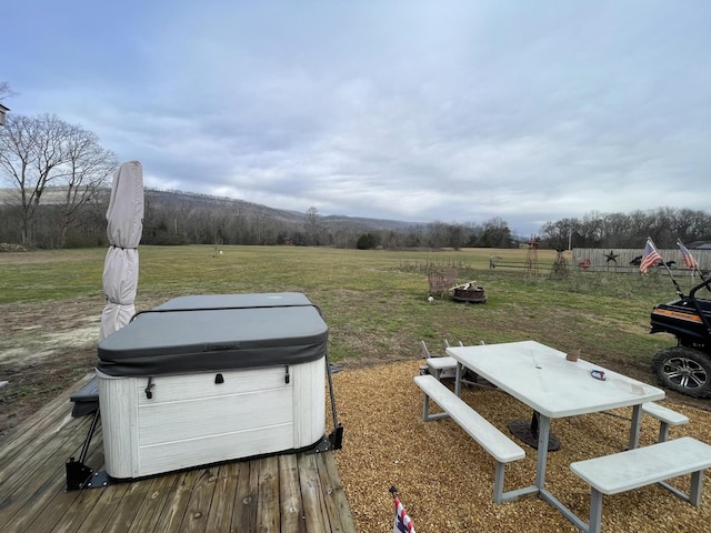 view of yard featuring a fire pit, a rural view, a wooden deck, and a hot tub