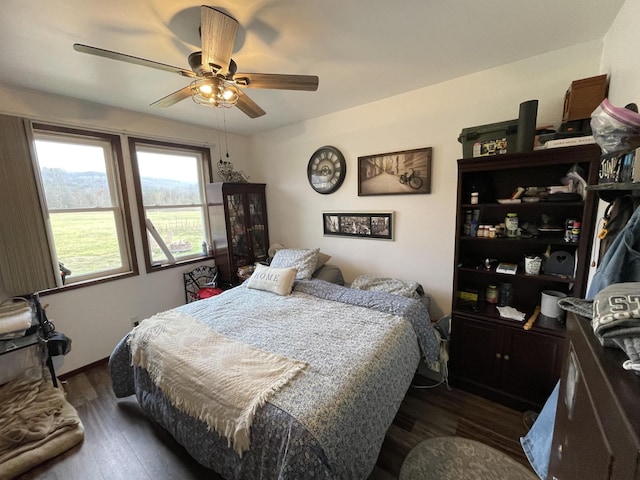 bedroom with ceiling fan and dark wood finished floors