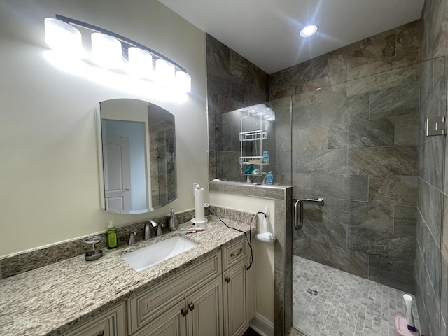 bathroom with a shower stall and vanity