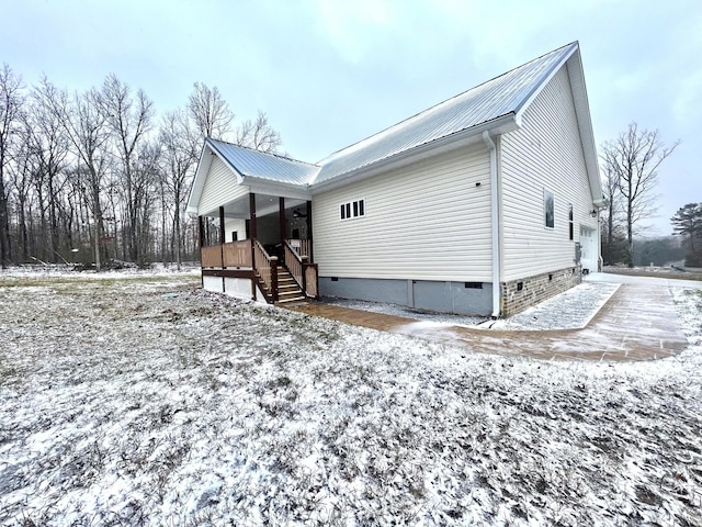 exterior space featuring a porch, crawl space, and metal roof