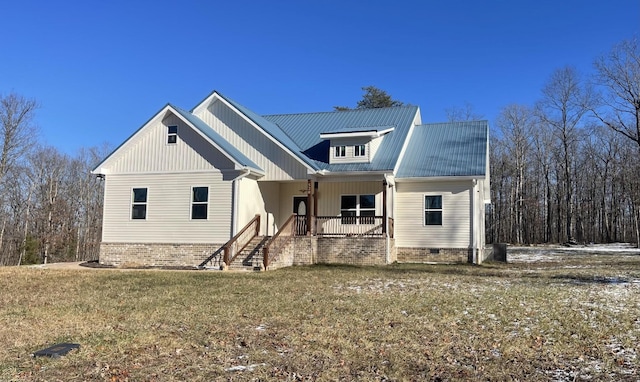 view of front facade featuring a porch, a front yard, crawl space, and metal roof