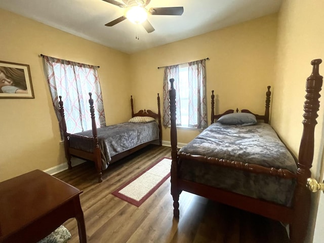 bedroom featuring a ceiling fan, baseboards, and wood finished floors