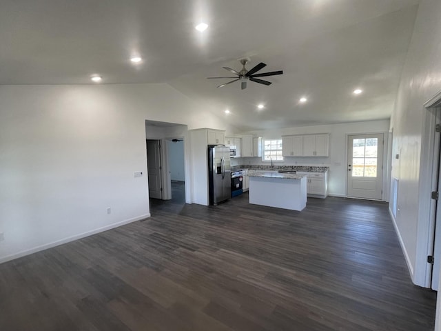 kitchen featuring stainless steel appliances, white cabinetry, open floor plan, a center island, and dark wood-style floors