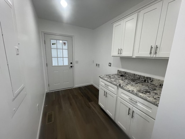 interior space with cabinet space, baseboards, visible vents, dark wood-style floors, and hookup for a washing machine