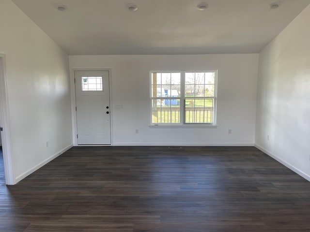 foyer featuring dark wood-style floors, baseboards, and vaulted ceiling