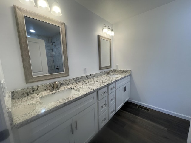 full bathroom featuring visible vents, a sink, baseboards, and wood finished floors