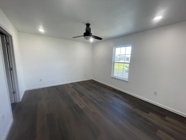 empty room with dark wood-style floors, recessed lighting, visible vents, ceiling fan, and baseboards