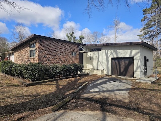 view of front of property featuring driveway, an attached garage, and brick siding