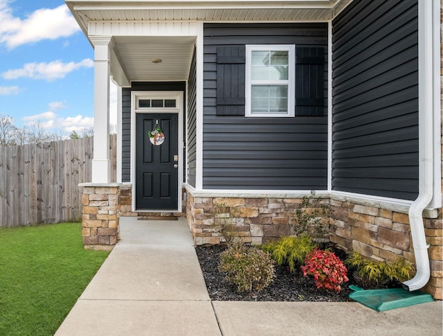 property entrance with stone siding and fence