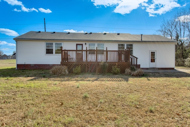 rear view of property with crawl space, a deck, and a lawn