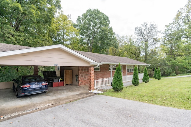 ranch-style house with brick siding, roof with shingles, an attached carport, driveway, and a front lawn