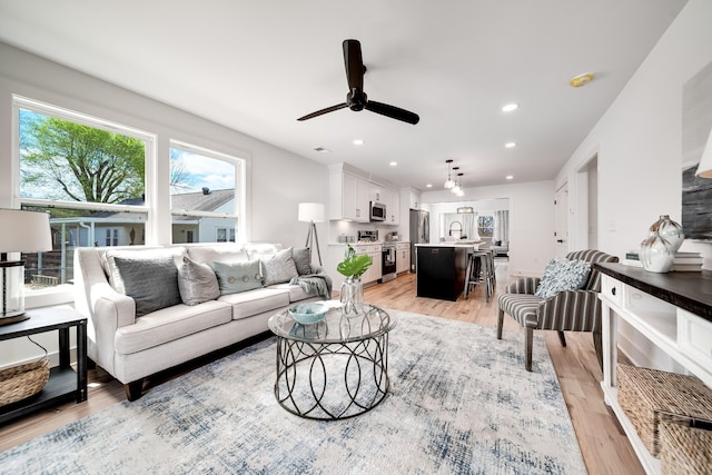 living room with ceiling fan, light wood-type flooring, and recessed lighting