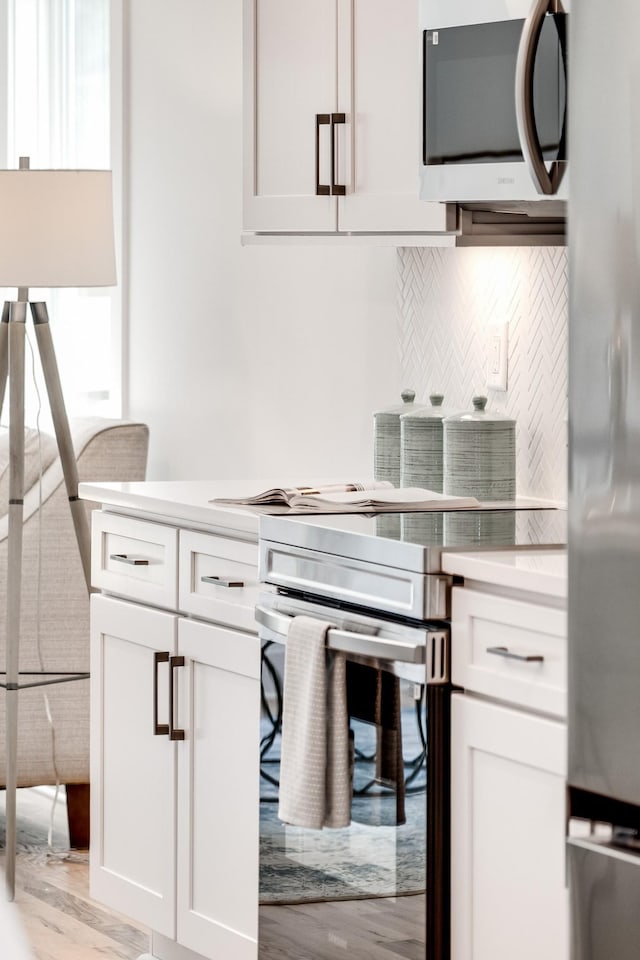 kitchen with white cabinetry, appliances with stainless steel finishes, and light countertops