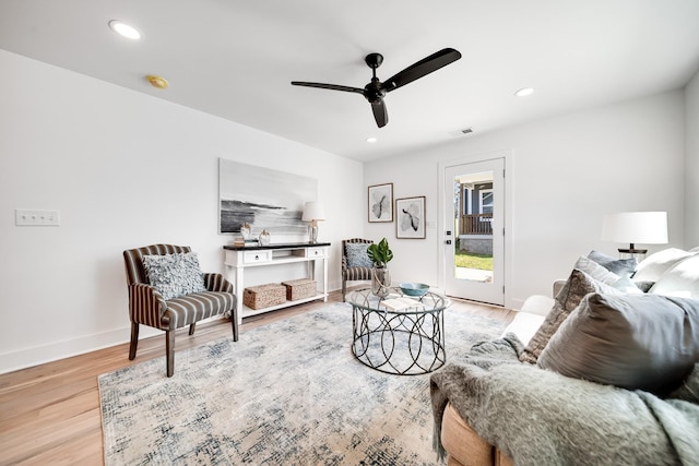 living area featuring visible vents, baseboards, light wood-style flooring, and recessed lighting