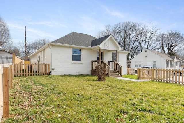 rear view of house featuring roof with shingles, brick siding, crawl space, and fence private yard