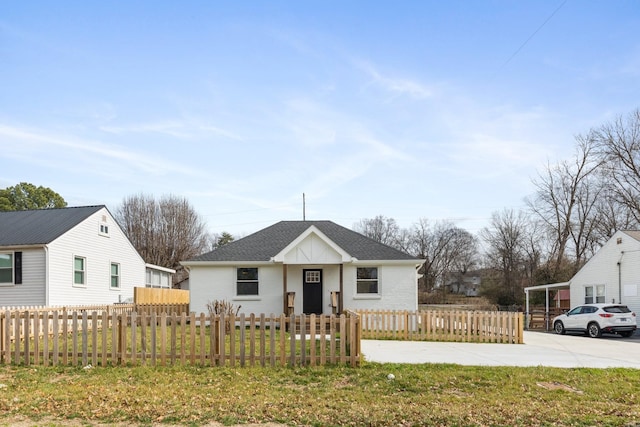 view of front of property featuring a shingled roof, a fenced front yard, and a front yard