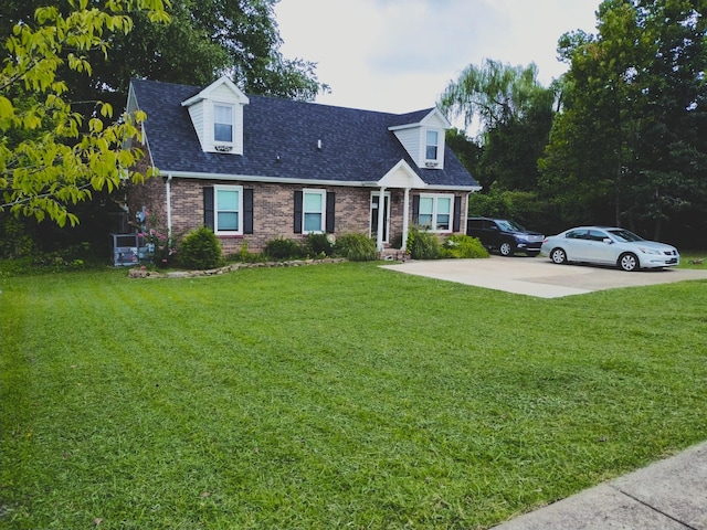 cape cod home featuring a shingled roof, a front lawn, concrete driveway, and brick siding