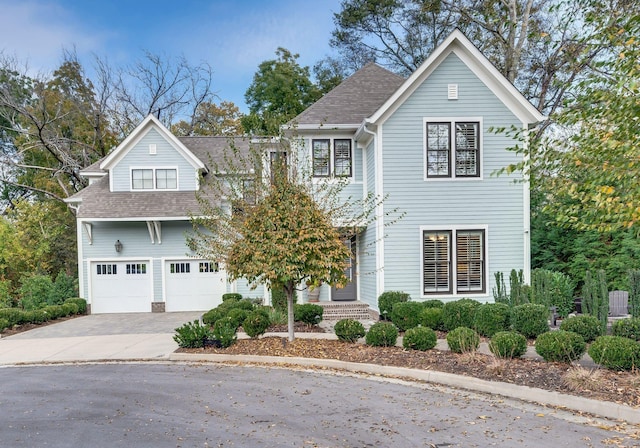 view of front of property with a shingled roof, driveway, and an attached garage