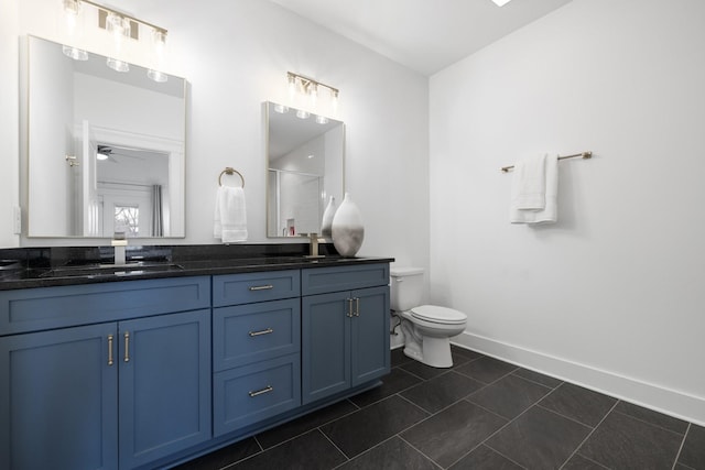 bathroom featuring double vanity, baseboards, toilet, tile patterned flooring, and a sink