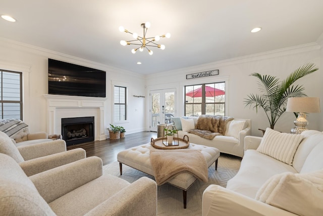 living room with recessed lighting, a fireplace, wood finished floors, ornamental molding, and an inviting chandelier