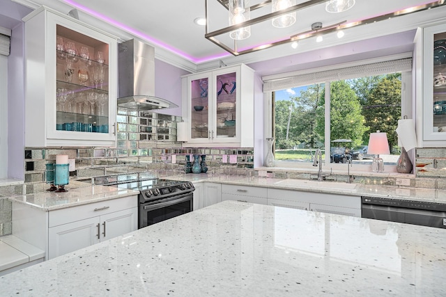 kitchen featuring glass insert cabinets, white cabinetry, a sink, and exhaust hood