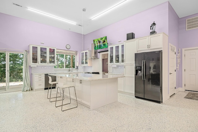 kitchen featuring glass insert cabinets, white cabinetry, a kitchen island, and refrigerator with ice dispenser