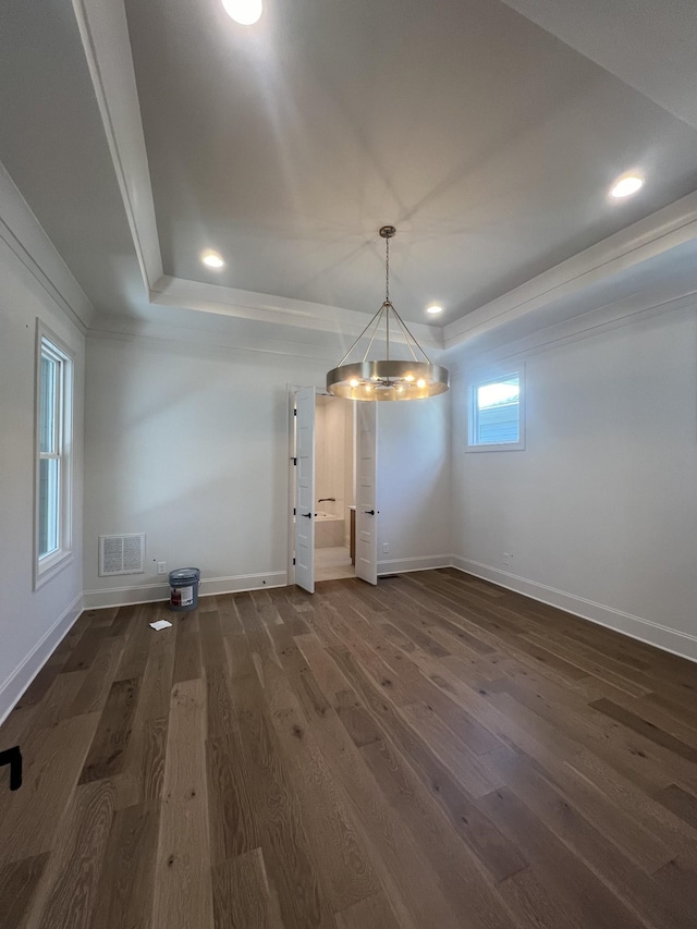 unfurnished dining area featuring recessed lighting, visible vents, baseboards, a raised ceiling, and dark wood finished floors