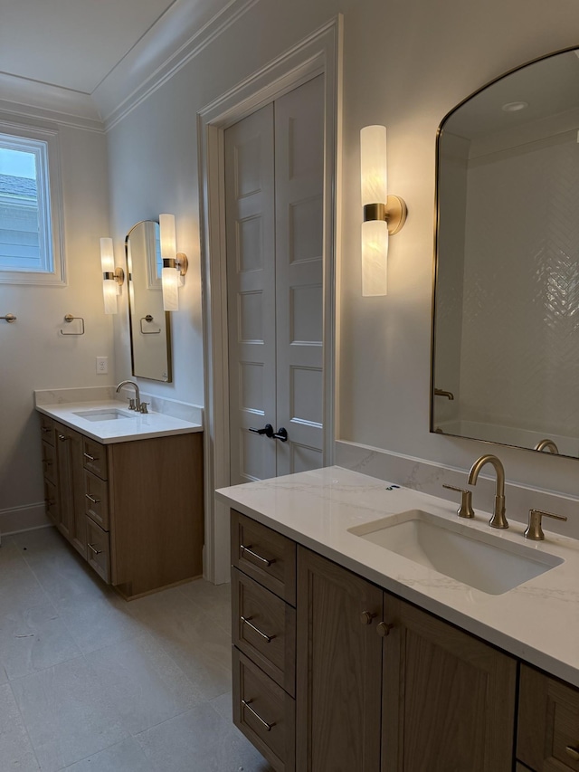 bathroom with ornamental molding, two vanities, and a sink