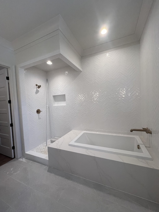 full bath featuring tile patterned flooring, tile walls, a tile shower, and a bath