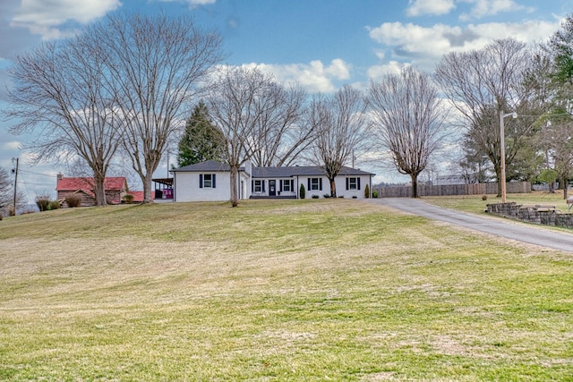 ranch-style house featuring driveway and a front lawn