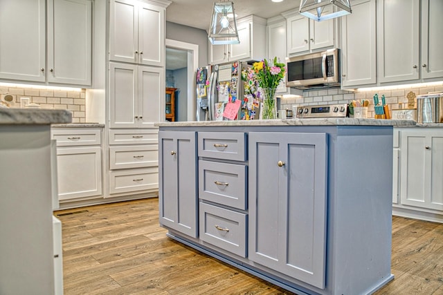 23 Hickman Hwy, Gordonsville, TN 38563 - kitchen with light wood finished floors, appliances with stainless steel finishes, gray cabinets, and decorative light fixtures