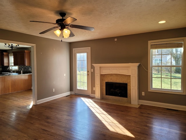 unfurnished living room with baseboards, visible vents, and dark wood-type flooring