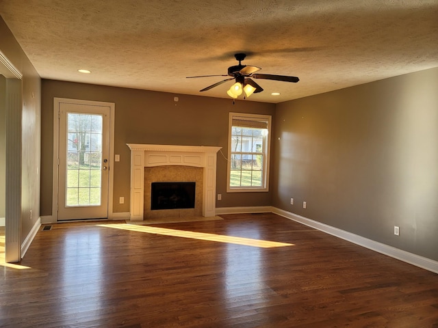 unfurnished living room with dark wood-style flooring, ceiling fan, baseboards, and a premium fireplace