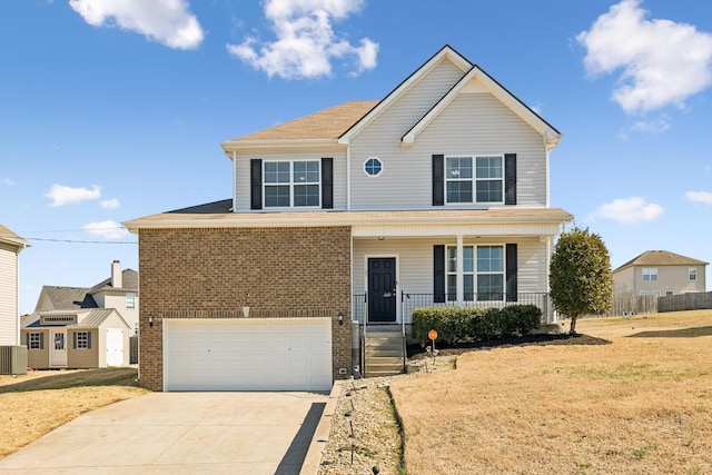 view of front of house featuring a front yard, covered porch, brick siding, and driveway