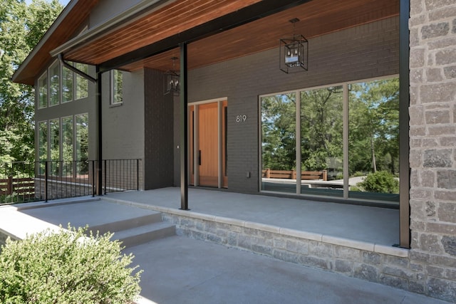 entrance to property with a patio area and brick siding