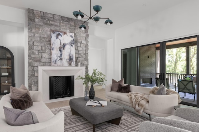 living room featuring a chandelier, french doors, and a fireplace