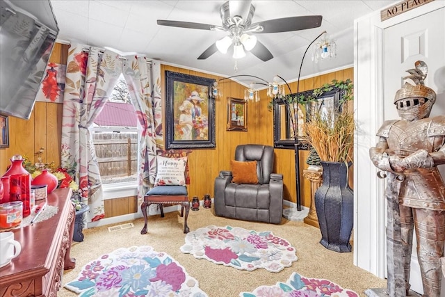 interior space featuring wood walls, carpet flooring, visible vents, and a ceiling fan