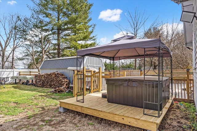 wooden deck with a fenced backyard, a lawn, a hot tub, and a gazebo