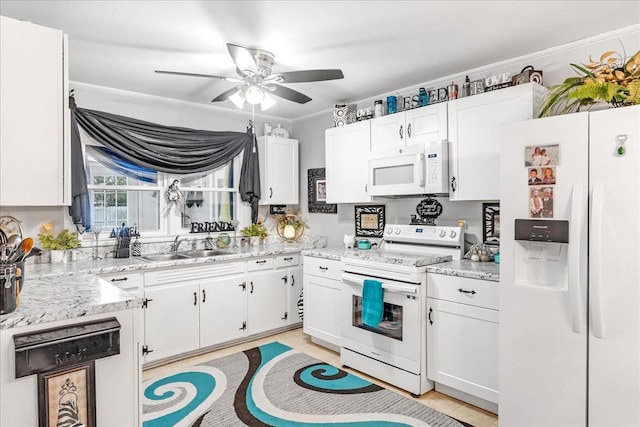 kitchen with ornamental molding, white appliances, white cabinetry, and a sink